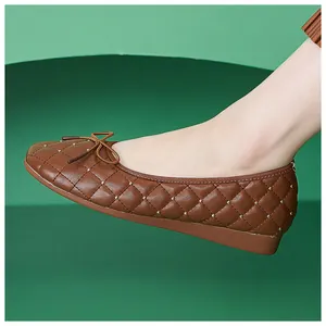 Detailansicht brauner gesteppter Ballerinas mit Schleife und goldenen Nieten