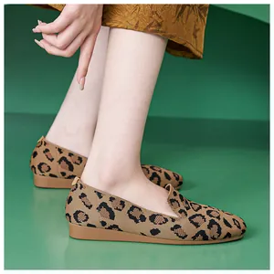 Detail trendiger Ballerinas mit Leopardenmuster und weicher Strickstruktur auf Stufen