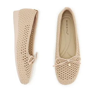Detail of apricot knitted flat shoes with hollow mesh texture and bow lock ornament