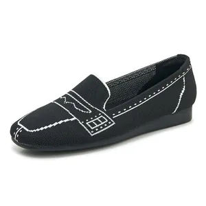 Detail von schwarzen Strick-Loafers mit weißen Kontrastnähten und weicher, flacher Sohle
