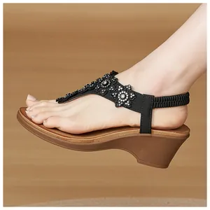Detail view of rhinestone floral embellishments on comfortable wedge thong sandals