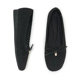 Detail of breathable knitted hollow-out flat shoes with bow and gold metal pendant