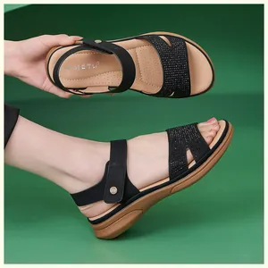 Detail of black wedge sandals featuring shimmering rhinestones and velcro closure