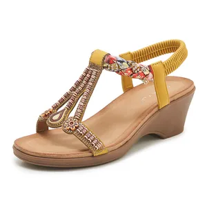 Détail de la sandale compensée jaune avec broderie de perles bohèmes et bride élastique