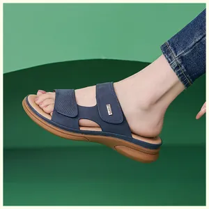 Side view of navy blue wedge sandals with textured strap and ergonomic brown sole