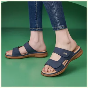 Detail of navy blue double-strap wedge sandals with arch support and gold logo