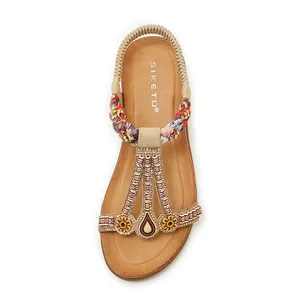 Détail de sandales plates bohèmes avec perles colorées et bride de talon élastique