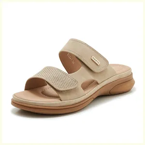 Close-up of beige wedge sandals with woven strap texture and gold brand logo detail