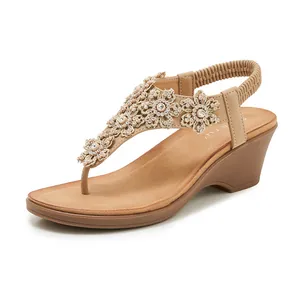 Detail of wedge sandals with rhinestones and floral applique on a T-strap design