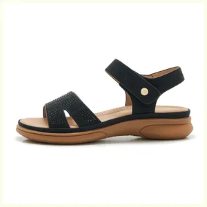Detail view of women's black wedge sandals featuring rhinestone straps and velcro closure