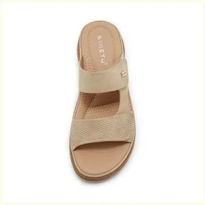 Detailed macro view of beige wedge sandals with woven texture and small metal buckle