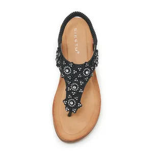 Detail of rhinestone flowers and elastic heel strap on black summer wedge sandals