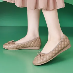 Beige Stepp-Ballerinas mit Nieten und Schleife in einer 45-Grad-Ansicht am Fuß gezeigt