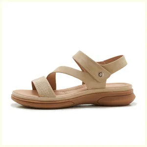 Detail of beige suede sandals featuring cross straps, velcro heel strap and cushioned sole