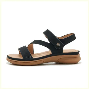 Close-up of black strappy wedge sandals with velcro ankle straps and metal buckle