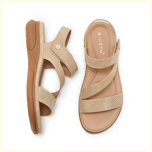 Macro view of beige wedge sandals featuring laser-cut details and velcro strap