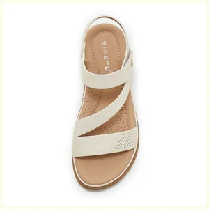 Close-up of cream cross-strap wedge sandals with perforated breathable footbed and stitching