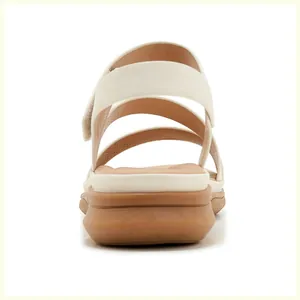Detail view of the wedge heel sandals with adjustable cream straps and velcro closure
