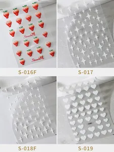 Detail of 3D nail art stickers with red strawberry and white star heart patterns