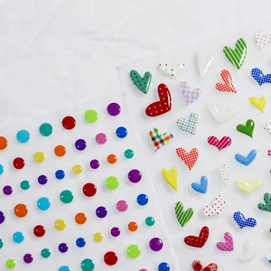 Bunte 5D-Nagelaufkleber mit geprägten Herz- und Punktmustern auf weißem Hintergrund