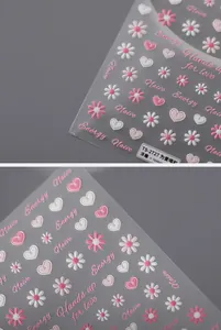 Makro-Detail von TS-2727 geprägten Nagelstickern mit Gänseblümchen- und Herz-Textur