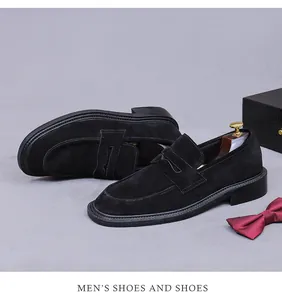 Detail of black suede penny loafers for men with wooden shoe tree and decorative bow tie