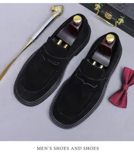 Detail of black suede loafers with premium stitching, gold shoehorn and luxury accessories
