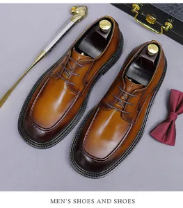 Detail of brown leather dress shoes with gradient finish, oxford laces, and grey background