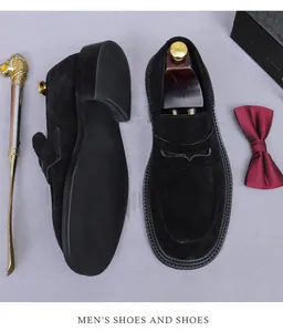 Detailed view of black suede leather loafers with metal shoe horn and bow tie accessories