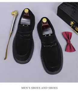 Classic black suede loafers shown with premium shoe trees and executive accessories