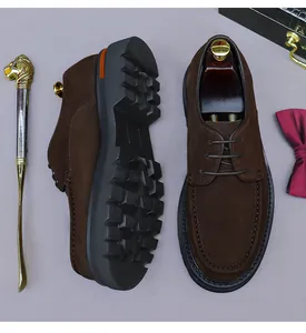 Dettaglio di scarpe derby da uomo in camoscio marrone con spessa suola in gomma antiscivolo