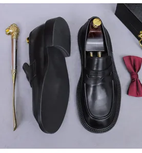 Draufsicht auf hochwertige schwarze Leder-Loafer mit eleganten Accessoires