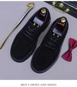 Vista dall'alto di scarpe da uomo in camoscio nero con cuciture a U e tendiscarpe in legno
