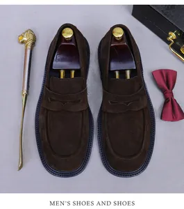 Detail of dark brown suede penny loafers with a cedar shoe tree and luxury accessories