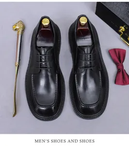 Top view of black leather derby shoes with decorative shoe horn and elegant bow tie