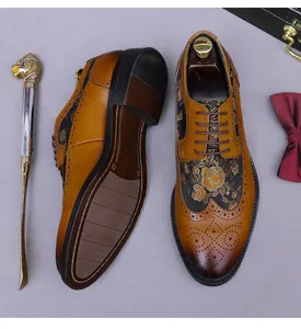 Detail of vintage brown brogue shoes featuring wingtip carving and gold floral embroidery