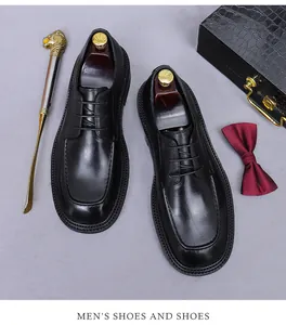Close-up of polished black leather men's dress shoes with professional business accessories