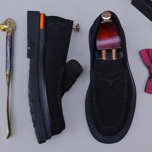 Mocassins pour hommes en daim noir avec semelles épaisses et détails orange, vue à plat