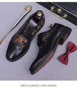 Detail of black leather brogue shoes featuring gold floral embroidery and wingtip perforations
