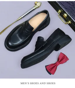 Dettaglio di mocassini in pelle nera premium con cinturino penny e accessori business