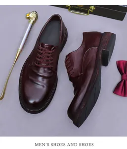 Details von dunkelburgunderroten Lederschuhen mit Faltenobermaterial und Herren-Accessoires