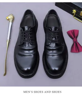Detailansicht schwarzer Derby-Schuhe aus Leder mit goldenem Schuhlöffel und Fliege