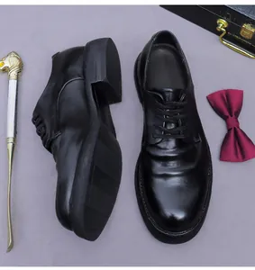 Detailansicht der schwarzen Leder-Derbyschuhe mit goldenem Schuhanzieher und Fliege