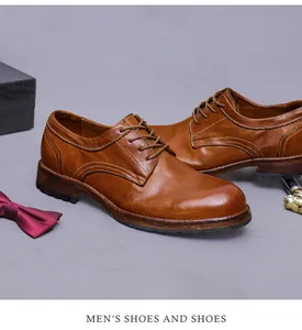 Detail van bruine leren Derby schoenen met stiksels, doos en vlinderdas voor heren
