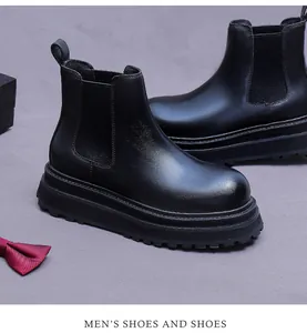 Detail of black leather Chelsea boot with elastic side panel and thick lug sole