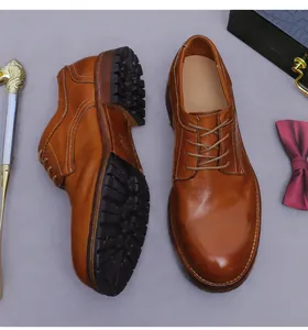 Detail van bruine leren derby-schoenen met dikke rubberen zolen en witte stiksels