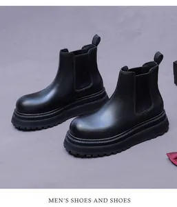 Detail of matte black leather chelsea boots showing elastic side and lugged platform sole