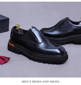 Nahaufnahme glänzender schwarzer Leder-Herrenschuhe mit orangefarbenem Detail an der Sohle
