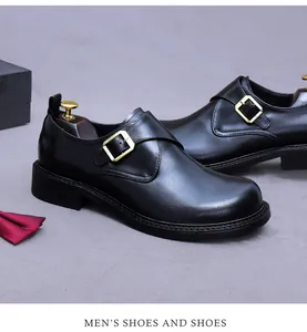Détail de chaussure monk noire en cuir avec boucle dorée et accessoire nœud papillon