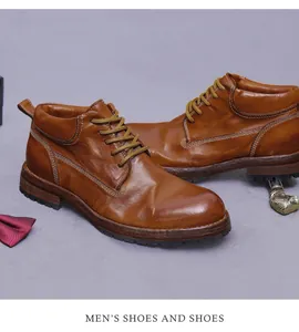 Close-up of brown leather men's work boots showing dual white stitching and woven laces